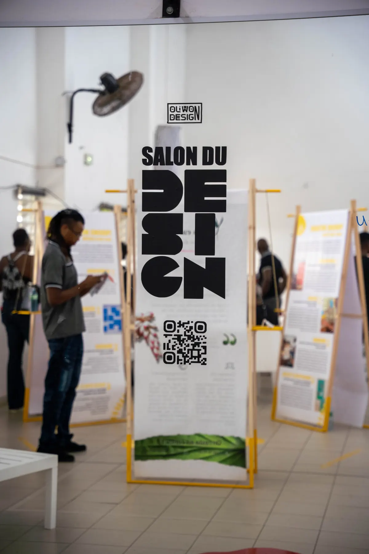 Kakémono « Salon du Design » d'OLIWON DESIGN installé dans une salle d'exposition où les visiteurs découvrent les panneaux